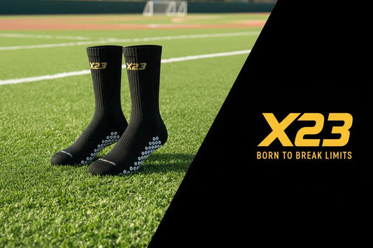 Black X23 grip socks with high-density 360° grip zones on green sports field turf